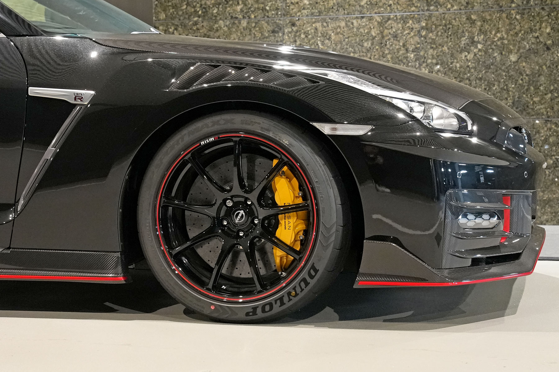 最終型2025年式 R35GT-R NISMOスペシャルエディション。専用カーボンフロントバンパーと赤いアクセントラインを備えた限定モデルの外観。メテオフレークブラックパールのボディカラーを撮影した販売車両の紹介画像。